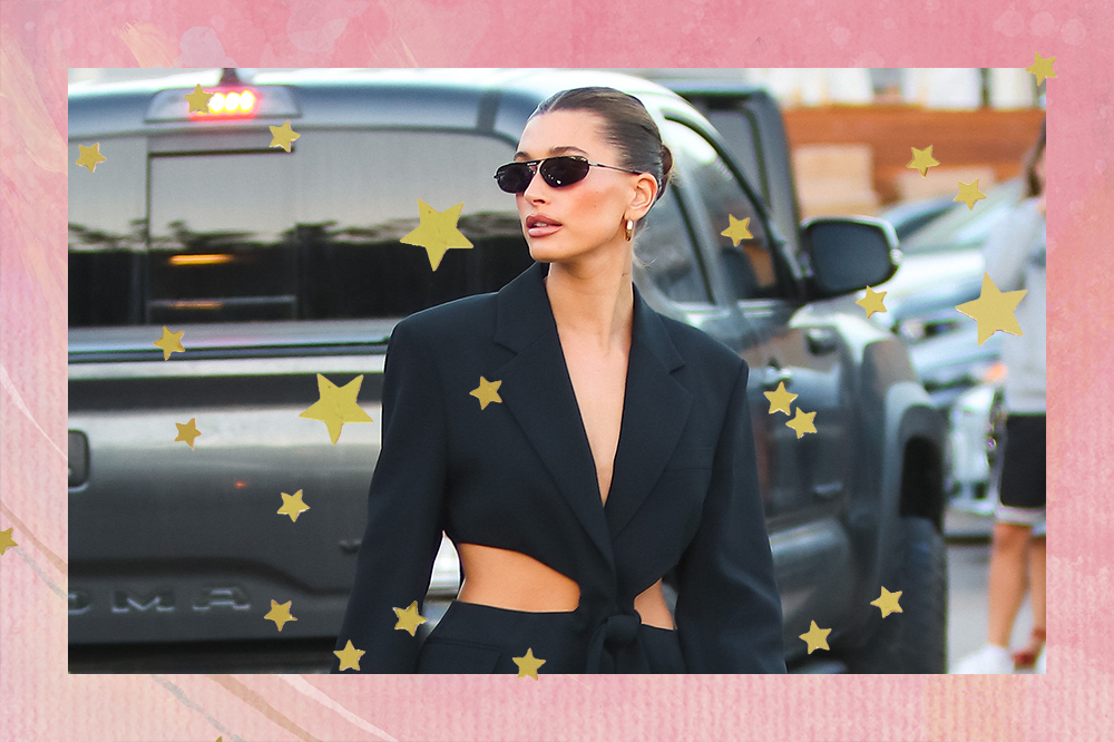 Montagem em fundo rosa com estrelinhas douradas de foto de Hailey Bieber usando vestido preto e óculos de sol enquanto olha para o lado