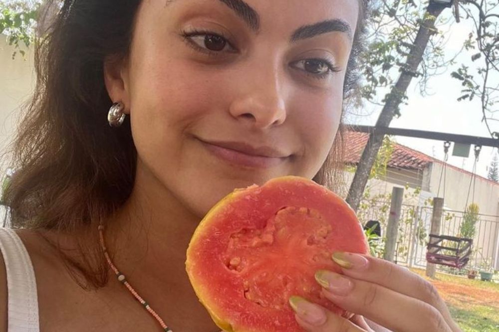 Camila Mendes posando para foto com uma goiaba