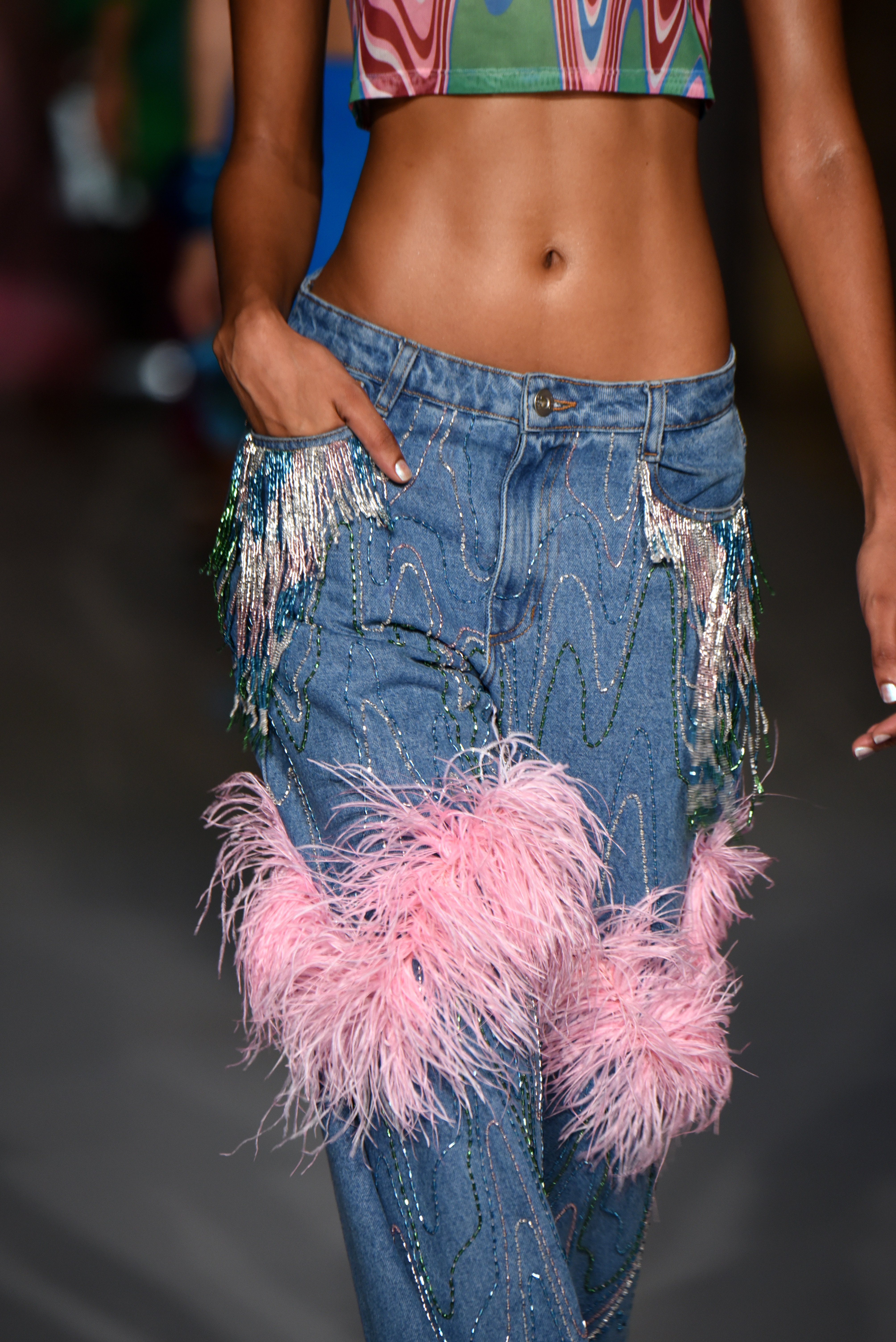 PatBo – Runway – September 2022 New York Fashion Week: The Shows Desfile de primavera-verão 2023 da PatBo na semana de moda de Nova York. Modelo usando calça jeans com aplicações de strass e plumas rosas