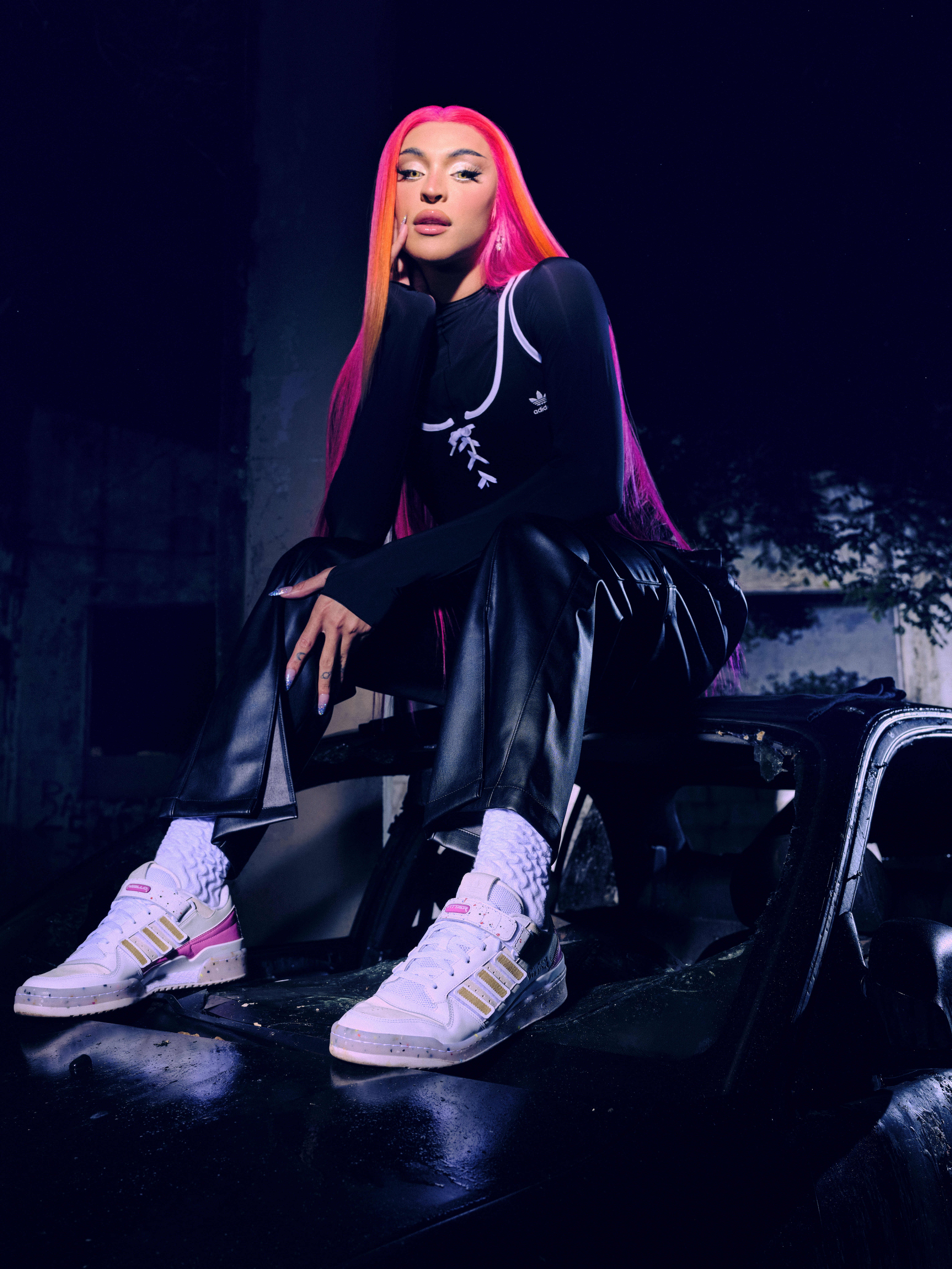 adidas-pabllo-vittar-colaboração-tenis-forum Pabllo Vittar posando em campanha da Adidas com peruca rosa, roupa preta e usando seu tênis branco e rosa em parceria com a marca