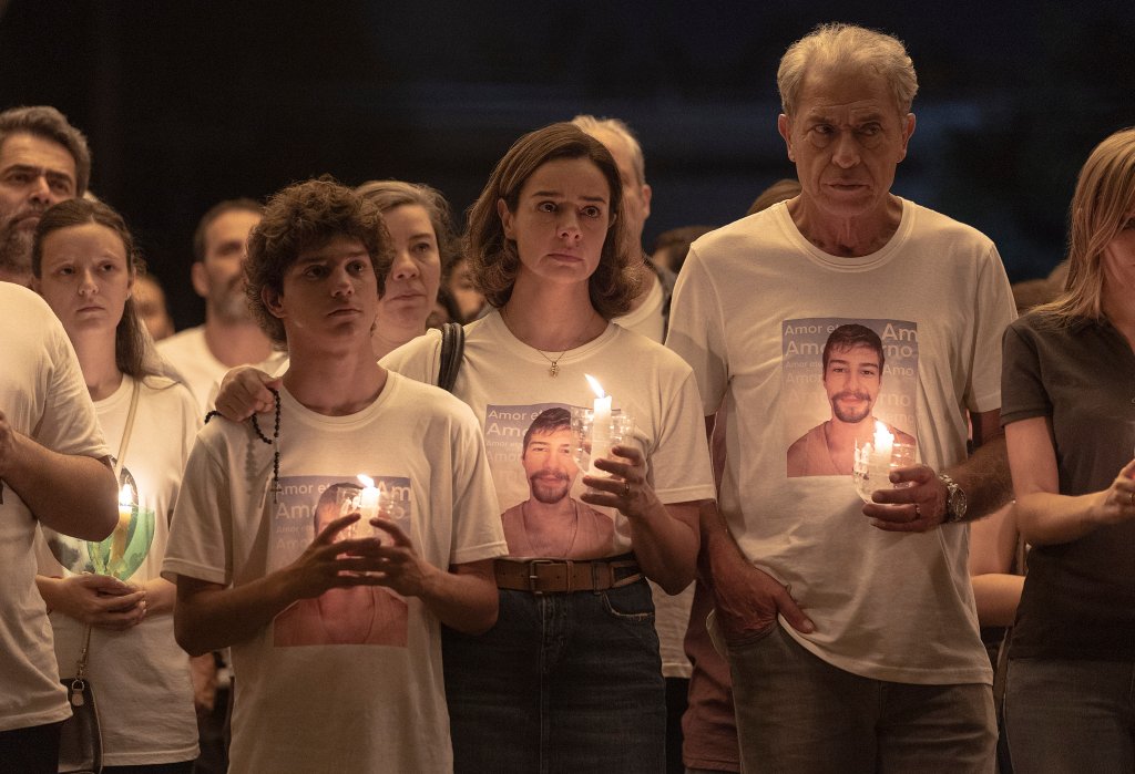 Pais e filho com vela na mão e camisetas estampadas iguais
