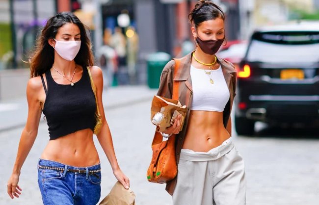 Bella Hadid e amiga usando calça de cintura baixa em looks casuais