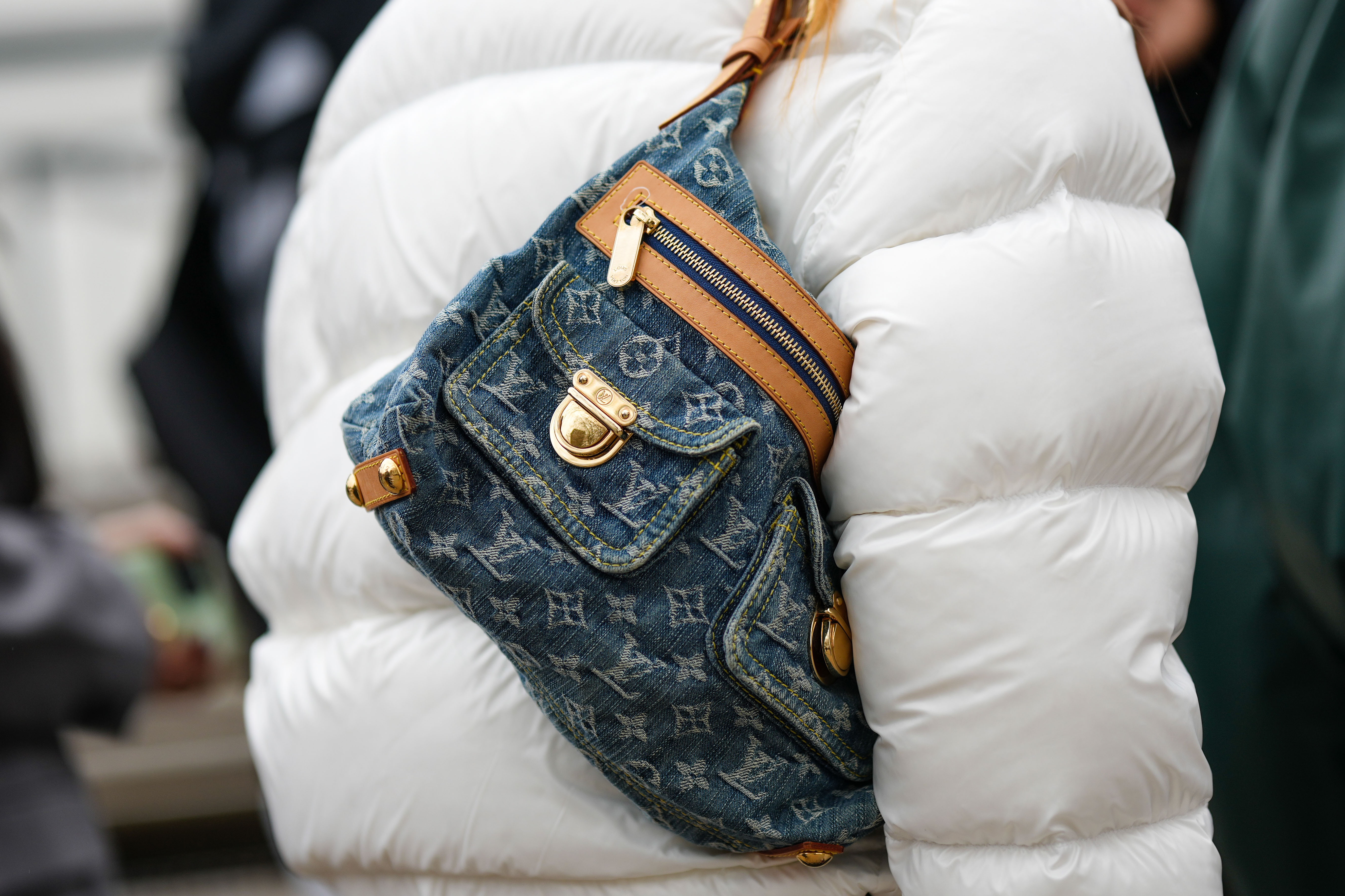 Street Style – LFW February 2023 Pessoa usando jaqueta puffer branca da Prada e bolsa jeans da Louis Vuitton no street style da semana de moda de Londres em fevereiro de 2023