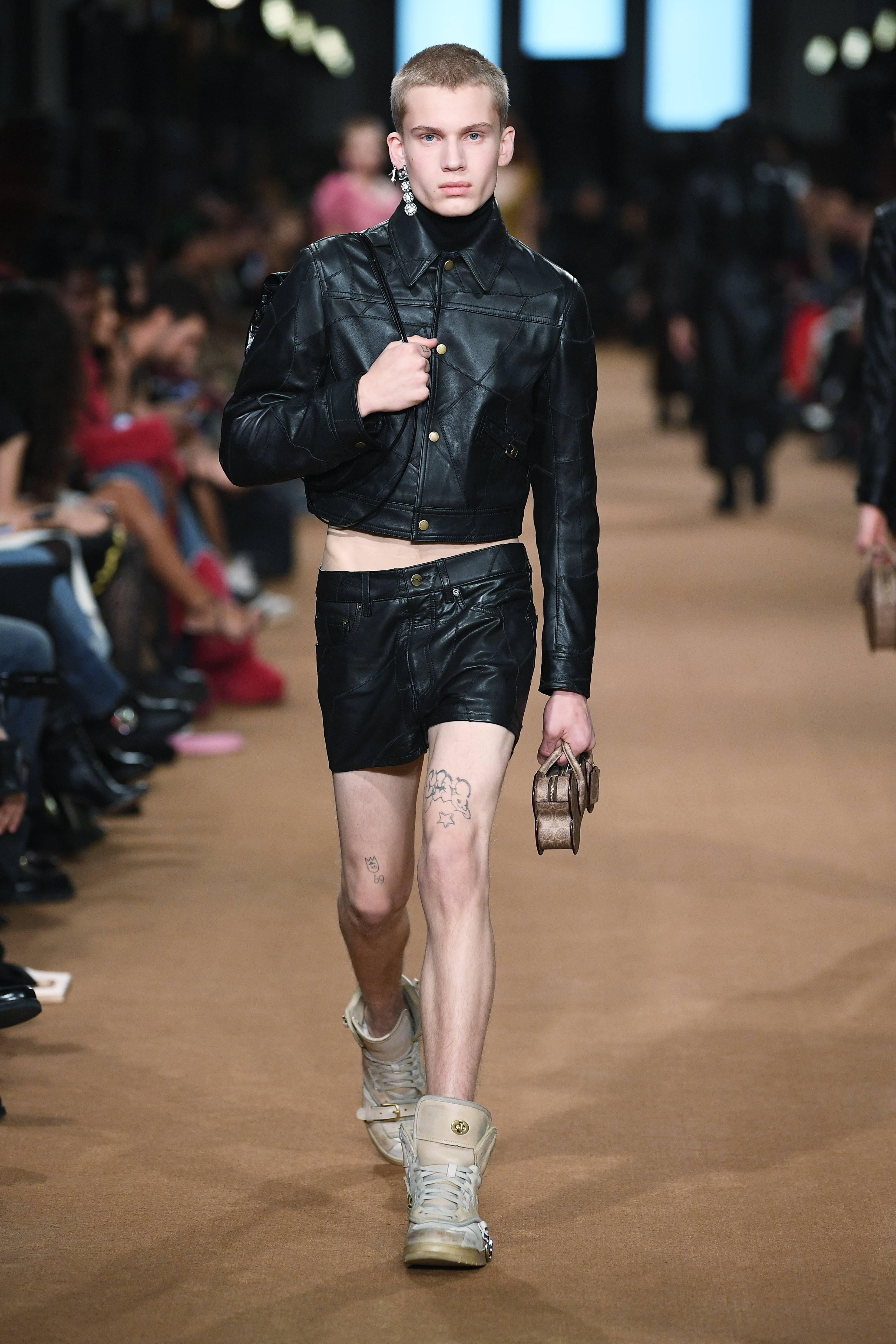 Coach – Fall 2023 – RTW – Runway Desfile de outono-inverno 2023 da Coach na semana de moda de Nova York. Modelo usando jaqueta e short preto de couros e tênis street de cano alto