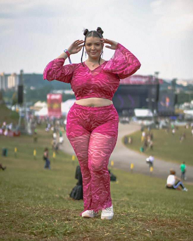 look-rosa-estampado-lollapalooza Foto de uma mulher no Lollapalooza 2023 com um look rosa com estampa psicodélica.