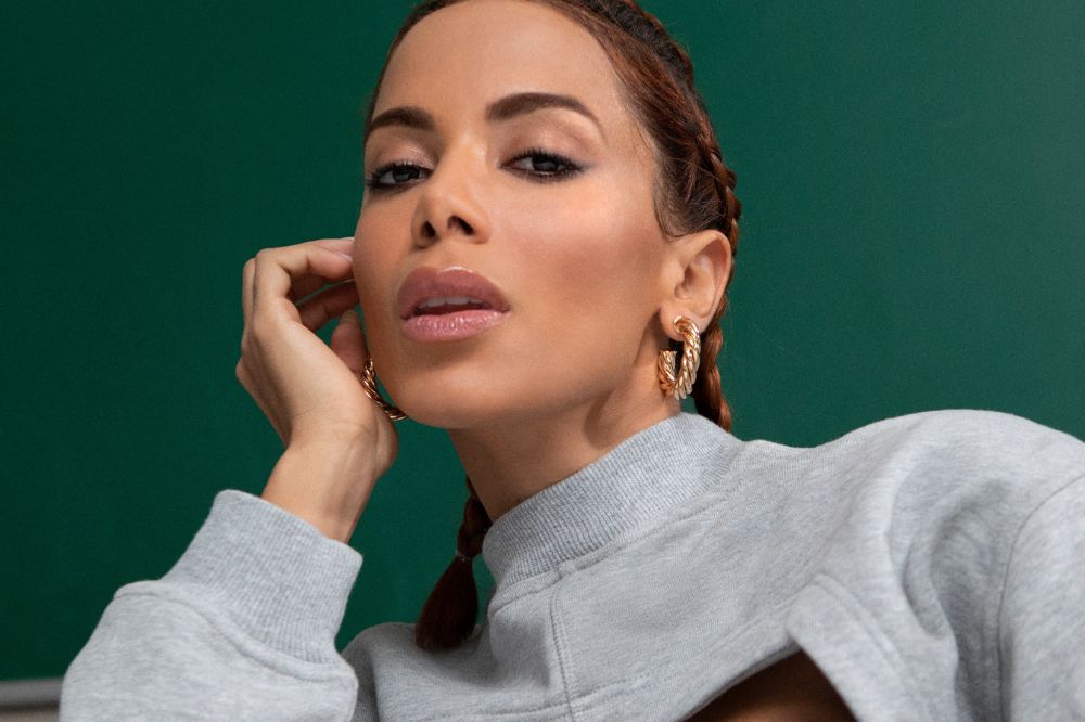 Anitta posando para foto em fundo verde