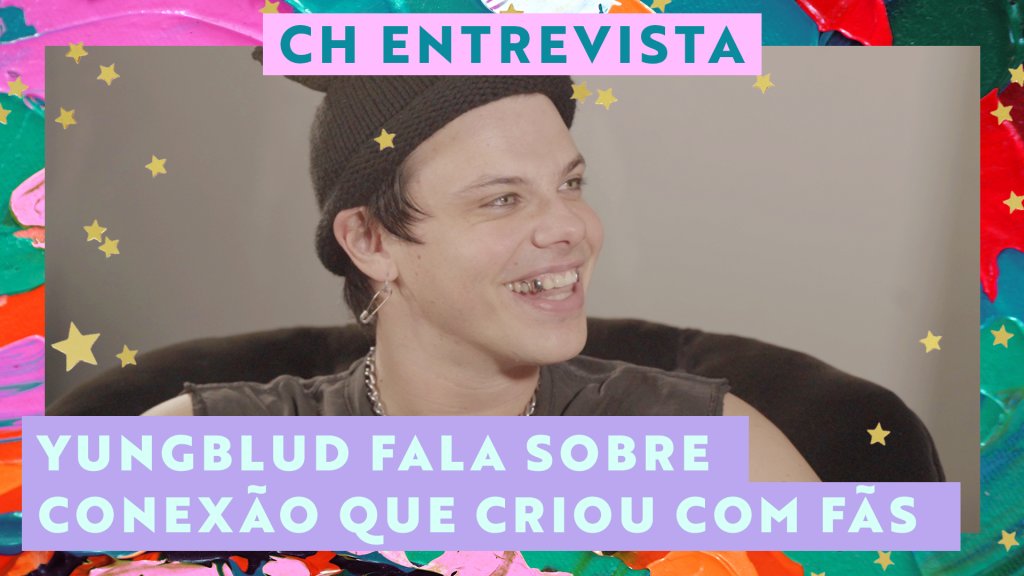 YUNGBLUD sorrindo enquanto olha para o lado em entrevista; a margem é uma textura nas cores rosa, verde, lilás e vermelho; na parte central superior "CH ENTREVISTA" está escrito em verde dentro de um retângulo rosa e na parte inferior esquerda o título "YUNGBLUD fala sobre conexão que criou com fãs" em verde dentro de um retângulo lilás; estrelas amarelas decoram a imagem