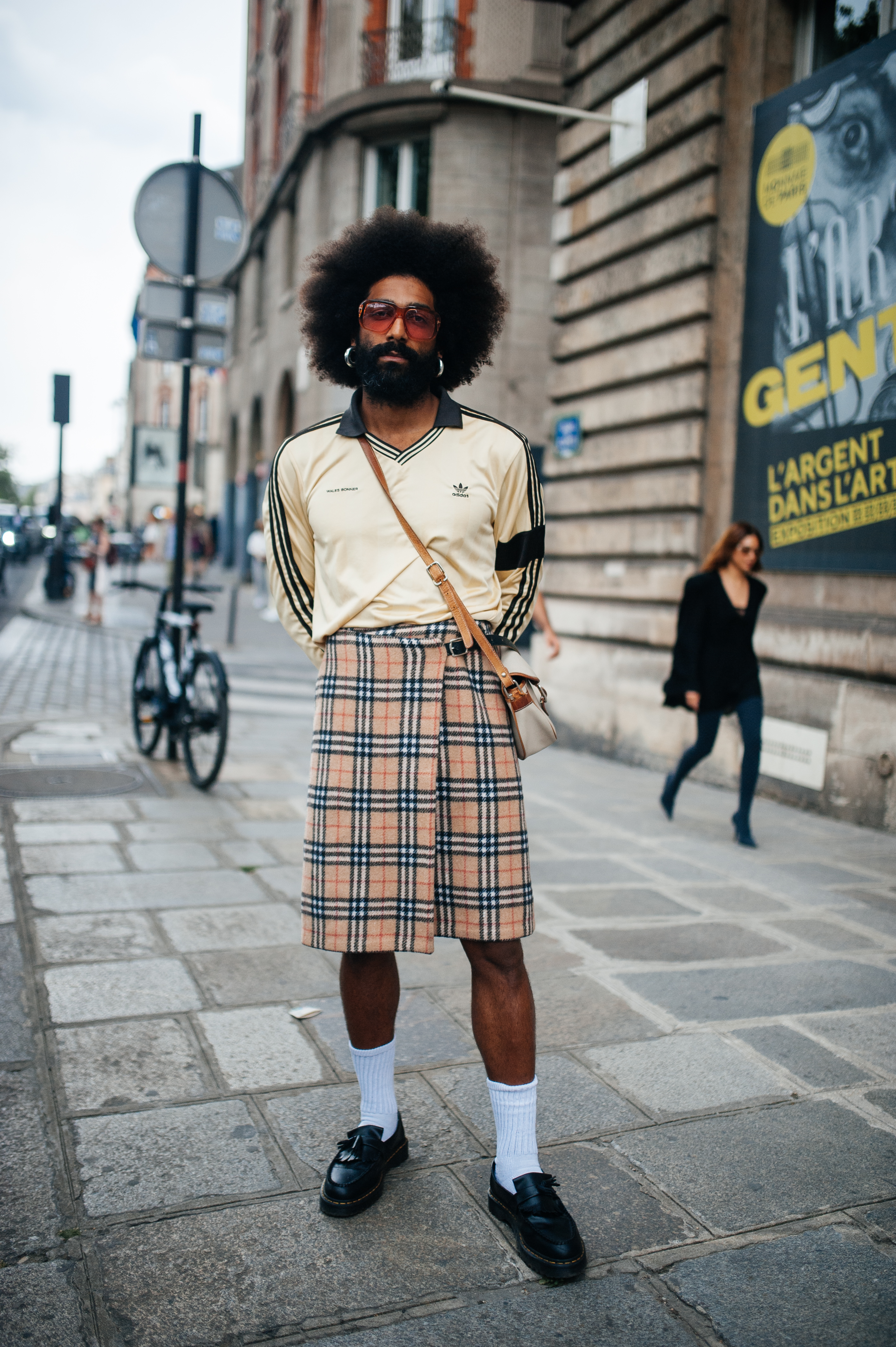 They Are Wearing: Men’s Fashion Week, Spring 2024- Paris Look no street style da semana de moda masculina de Paris. Homem usando camisa Adidas, saia xadrez e meia branca com tênis
