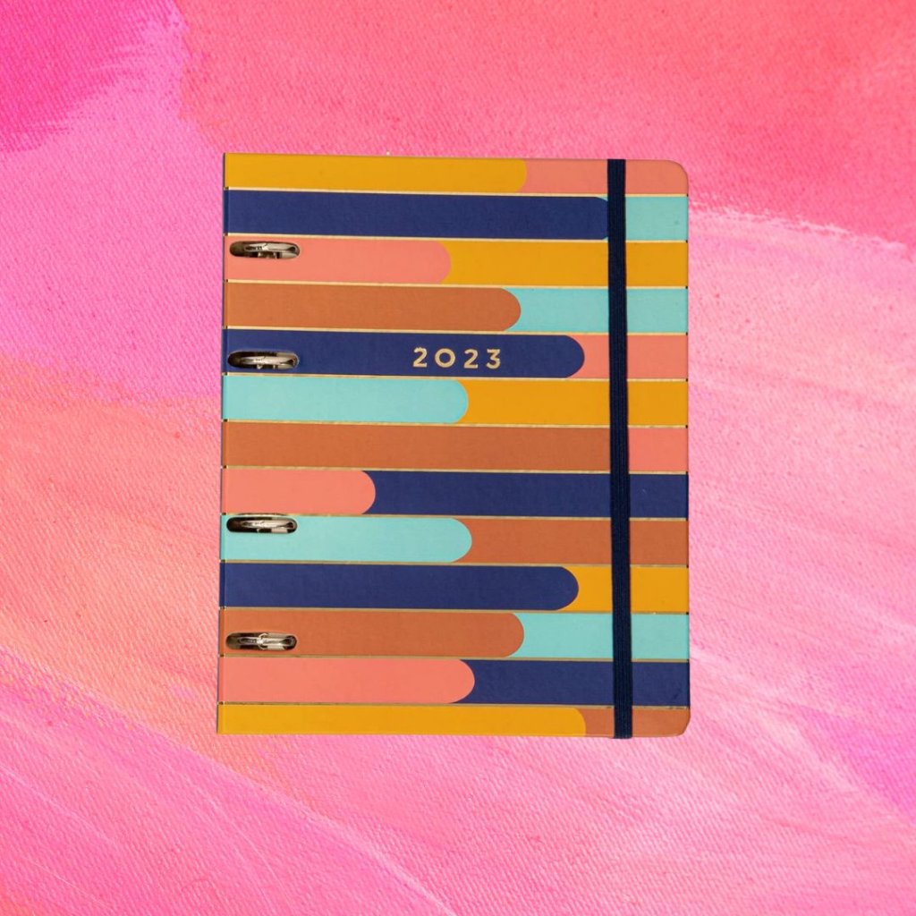 planner (9) Planner com linhas coloridas e uma tira azul escuro; o fundo é uma textura em tons de rosa e branco