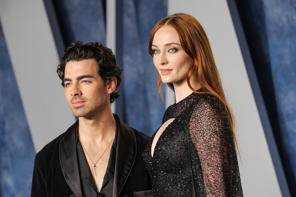 Joe Jonas e Sophie Turner posando para fotos na festa pós-Oscar 2023 da Vanity Fair com expressões neutras