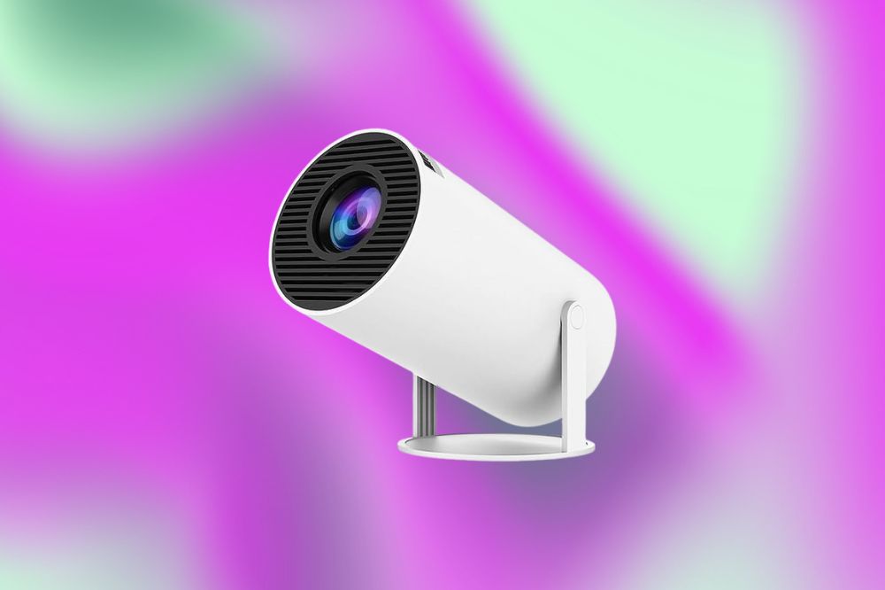 Em um fundo verde e roxo, o projetor é cilíndrico, branco, com a base da frente, onde fica a lente, preto