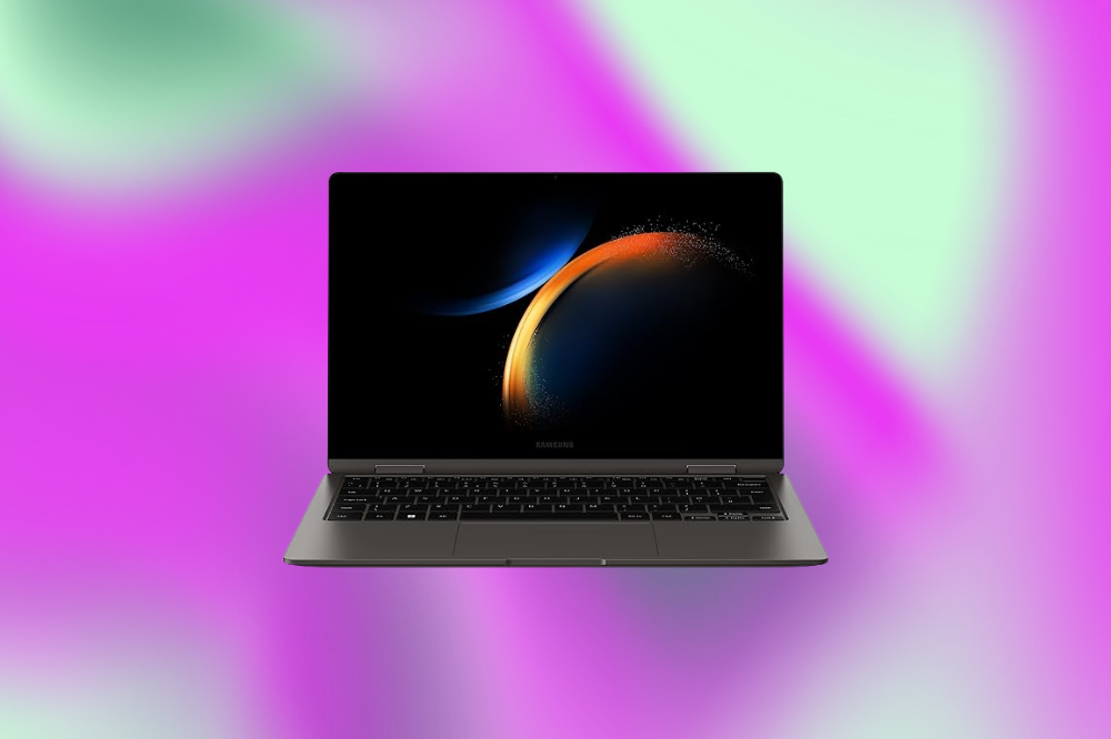 Imagem de um laptop cinza escuro em um fundo roxo e verde claro