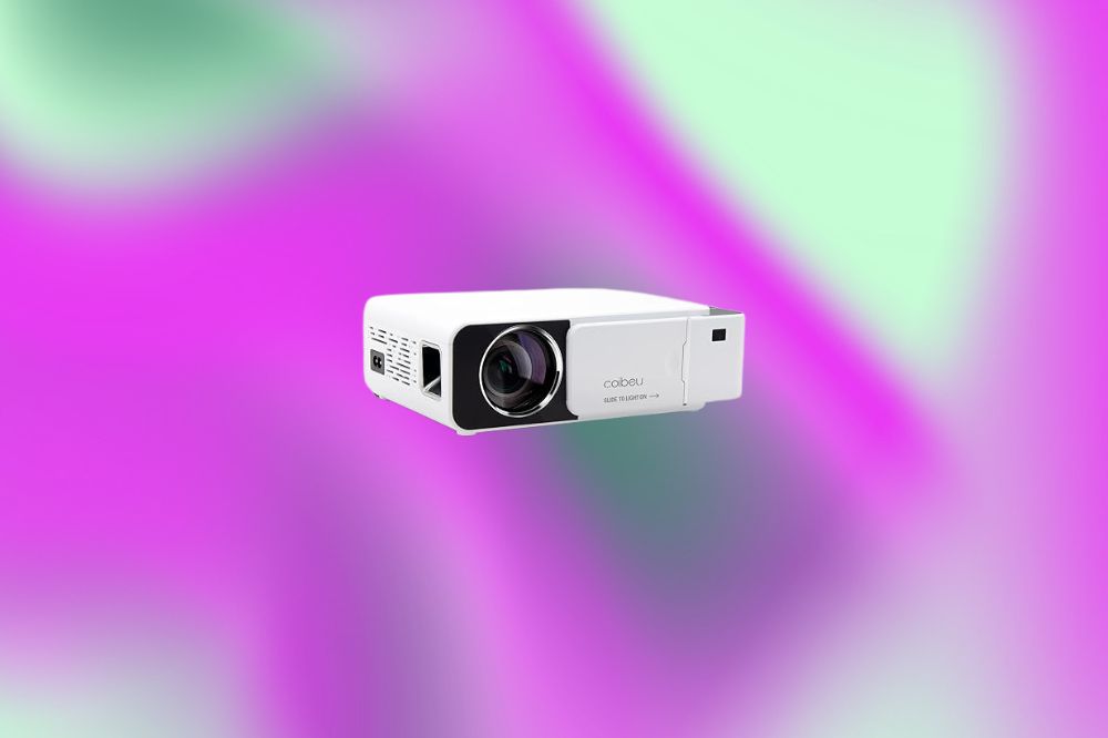 Em um fundo verde e roxo, há um mini projetor branco com apenas a parte da frente do lado direito preta, bem onde está o visor