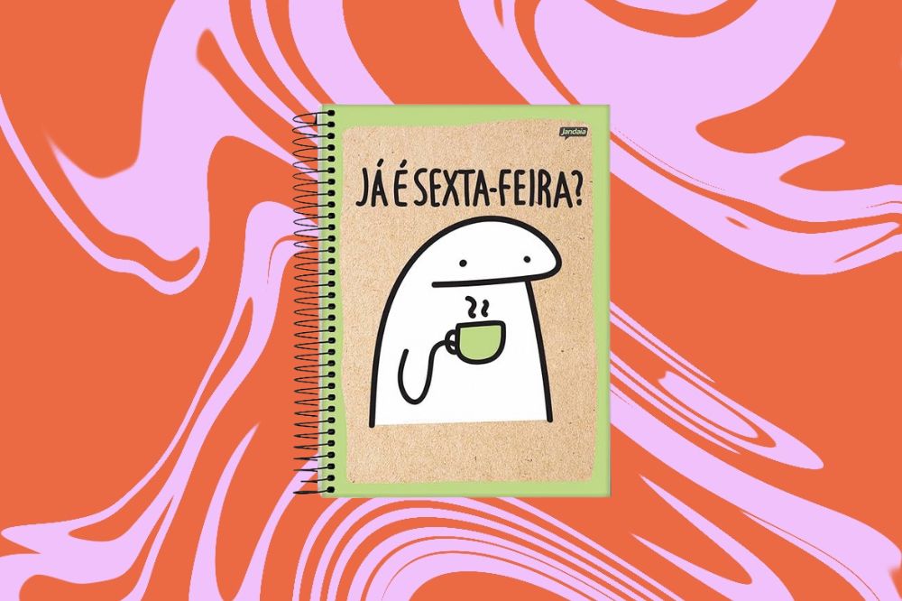Caderno com capa imitando madeira com o meme "Já é sexta-feira?" e um boneco em branco, em um fundo laranja e rosa