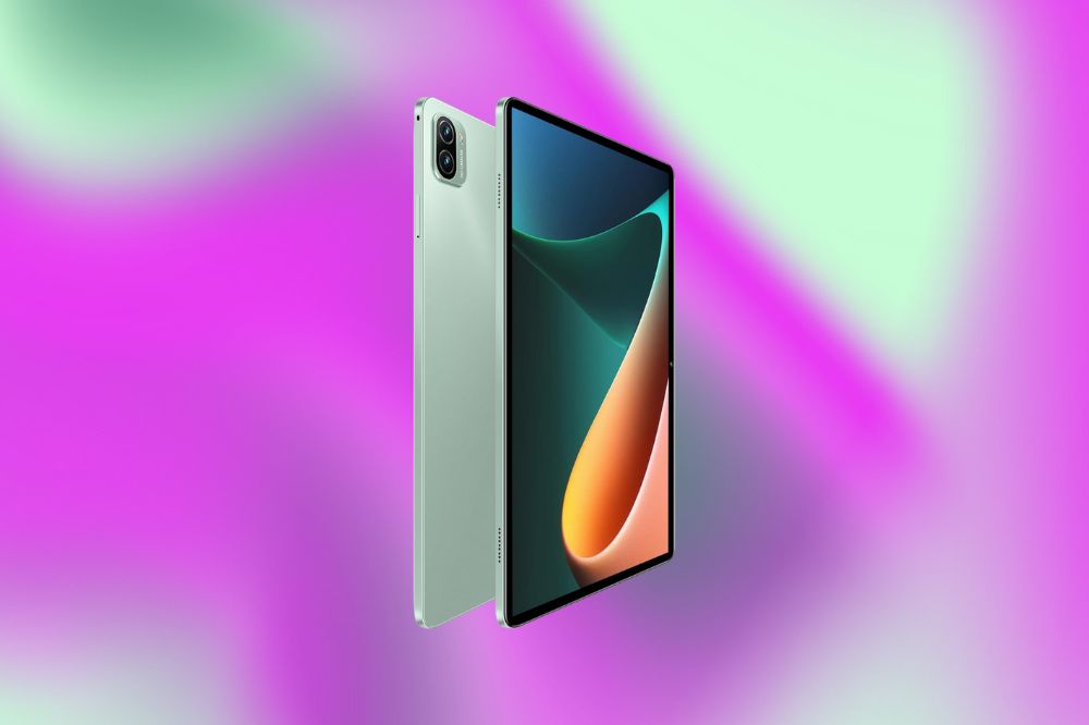 Imagem de um tablet verde claro em um fundo roxo e verde.