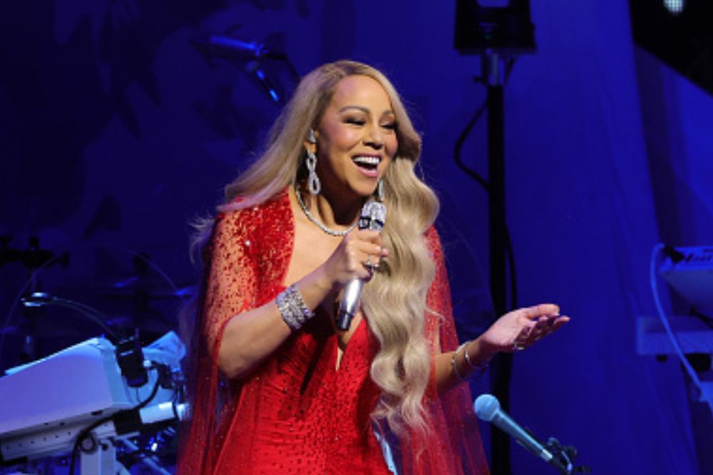 Cantora de vestido vermelho e cabelo loiro sorrindo