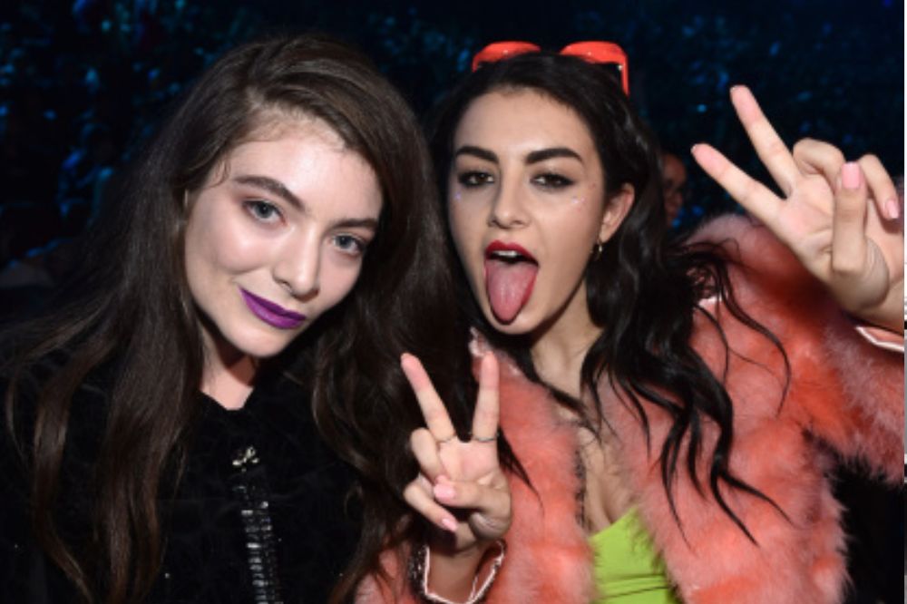 Foto das cantoras Charli XCX e Lorde abraçadas e fazendo pose