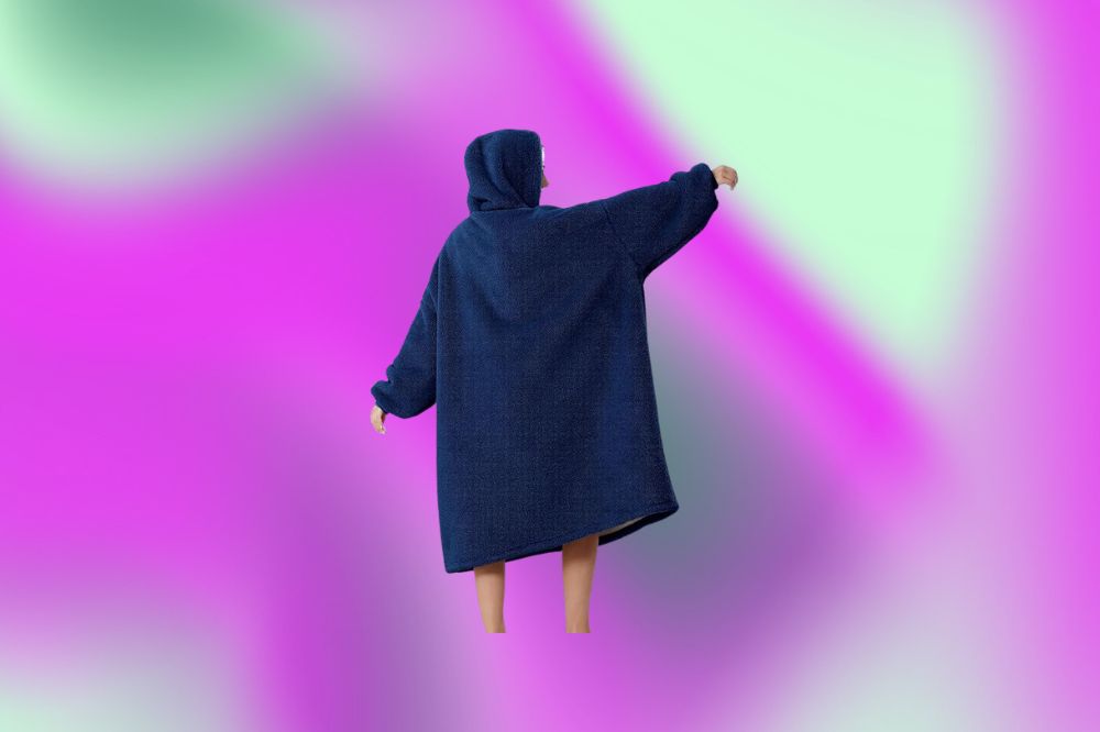 Imagem de uma manta vestível azul em fundo roxo e verde.