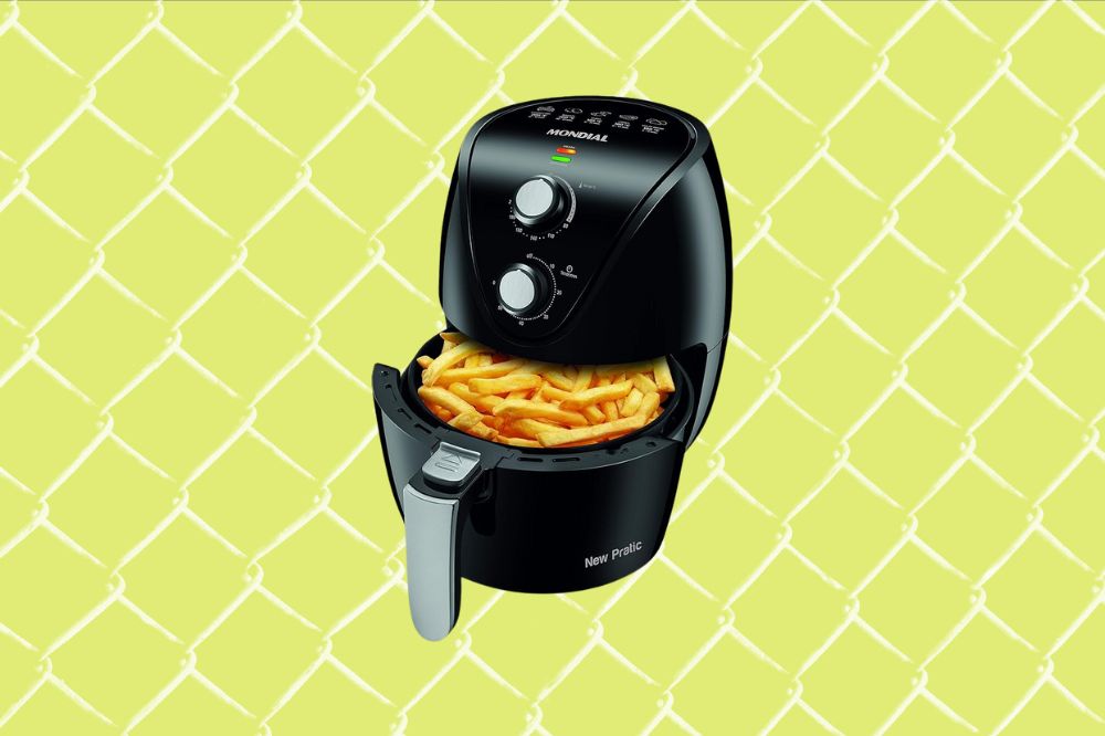 Imagem de uma air fryer preta aberta com batata frita dentro, em um fundo amarelo.