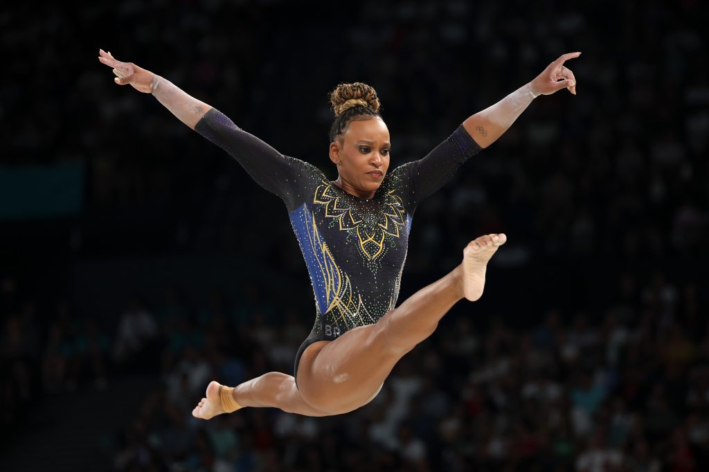 Imagem da ginasta Rebeca Andrade dando um salto nas olimpíadas de Paris.