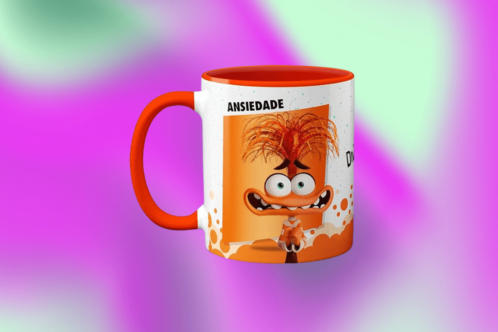 Imagem de uma caneca branca e laranja com o boneco da Ansiedade, de Divertida Mente 2 no meio em um fundo roxo e verde.