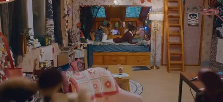 Os quartos da ficção mais legais para você tirar ideias de decoração para o seu Imagem da personagem Lim Joo de Beleza Verdadeira, deitada na cama do quarto.