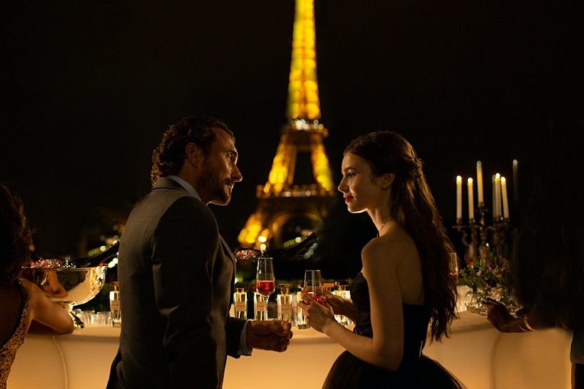 Cena de Emily em Paris, com Emily e Antonie em um terraço com vista para a Torre Eiffel.